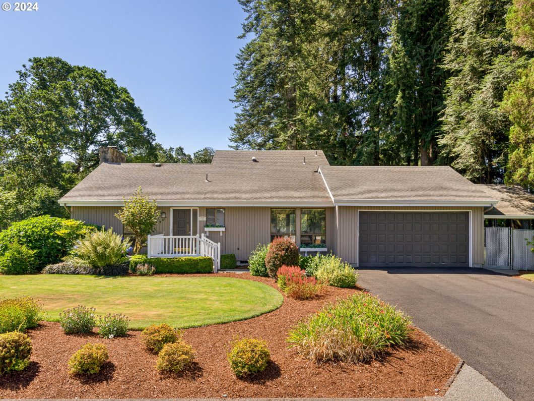 A single-story home with a gray exterior, attached double garage, and landscaped front yard.