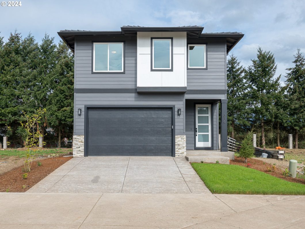 A modern two-story home with a gray facade, double garage, and clean landscaping.